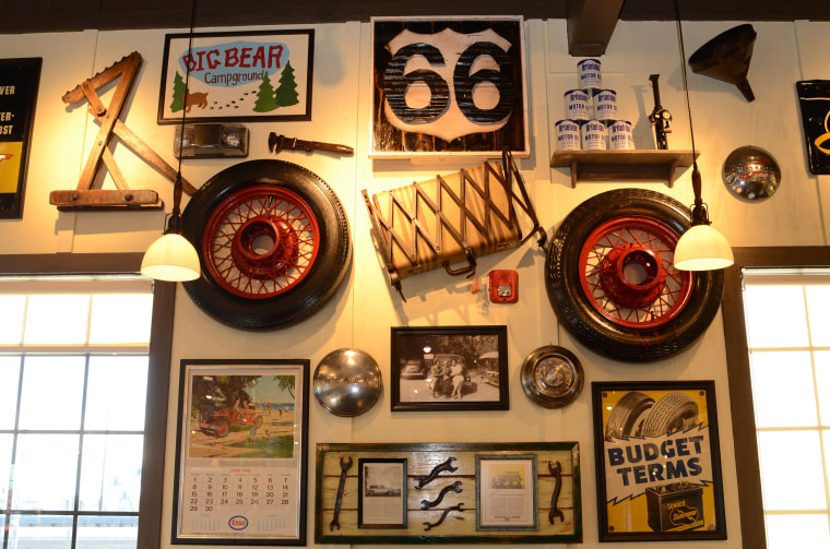 Historical decorations pay homage to California's Route 66, such as an antique tire, luggage rack and suitcase, old motor oil cans, and an antique Esso calendar from June 1969.