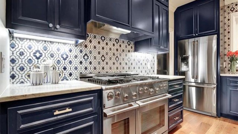 A kitchen with dark blue cabinets