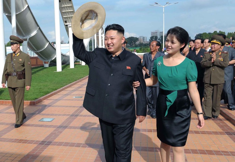 North Korean leader Kim Jong-un, center, accompanied by his wife Ri Sol Ju, right, waves to the crowd as they inspect the Rungna People's Pleasure Ground on July 25, 2012 in Pyongyang, North Korea.