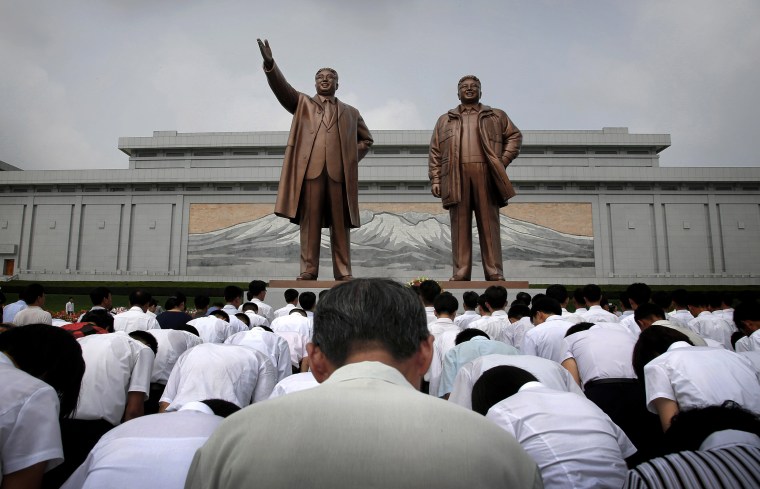 North Koreans bow in front of bronze statues of the late leaders Kim Il Sung and Kim Jong Il at Munsu Hill, on July 27, 2015, in Pyongyang, North Korea. North Koreans gathered to offer flowers and pay their respects to their late leaders as part of celebrations for the 62nd anniversary of the armistice that ended the Korean War.