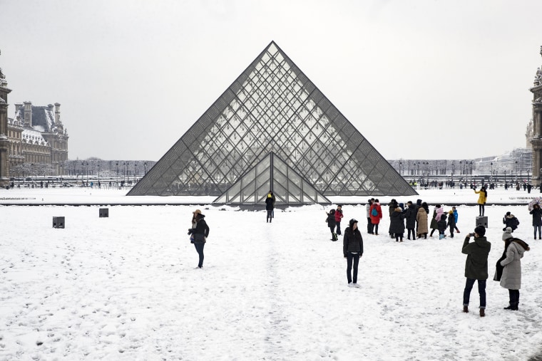 Tourists take photos outside the Louvre on Feb. 7.