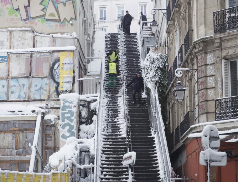 City employees clear snow from a staircase in Montmartre on Feb. 7.