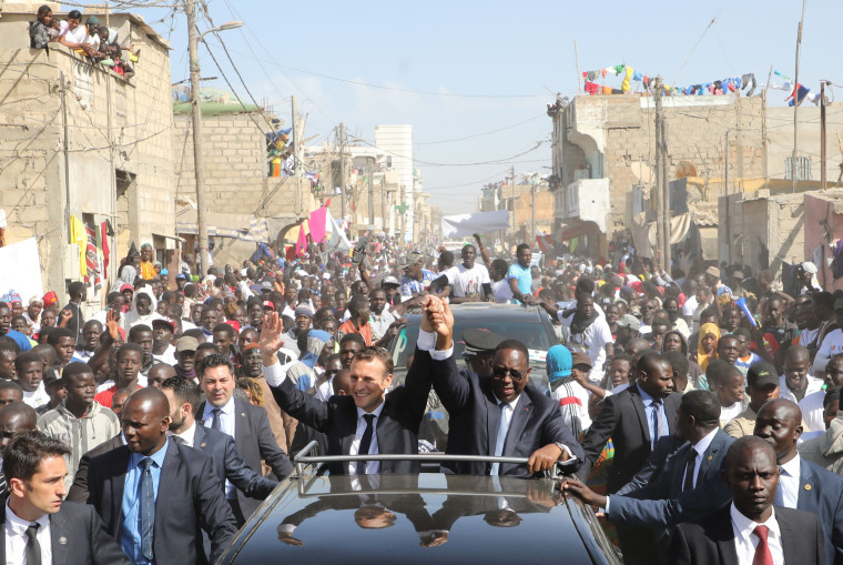 French President Emmanuel Macron and Senegalese President Macky Sall wave to the crowd in Saint-Louis on Feb. 3, the final day of Macron's visit to Senegal.