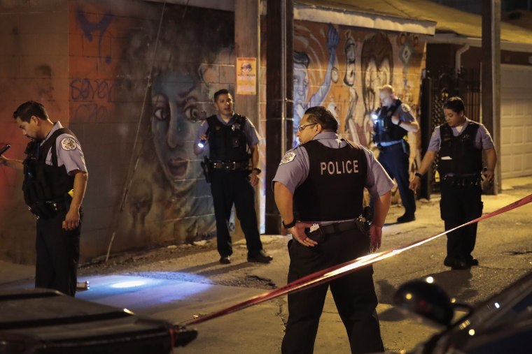 Image: Police search for evidence after a man was shot in the Little Village neighborhood of Chicago