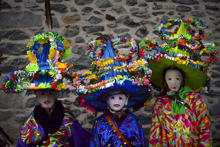 A group of participants dressed in traditional clothes and wearing large hats decorated with ribbons and feathers, known as ''Ttutturo'', take part in the Carnival of the Pyrenees villages of Leitza, northern Spain on Jan. 30, 2018.