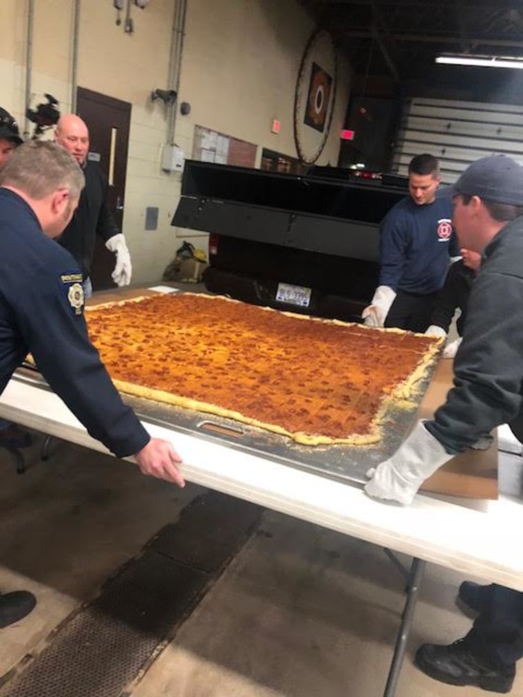 Mallie's Grill and Bar, Southgate, MI, delivers largest commercially available pizza to local fire department.