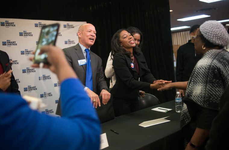 Image: Dallas County district attorney candidates, Judge John Creuzot, left, and Judge Elizabeth Frizell shake hands with members of the audience