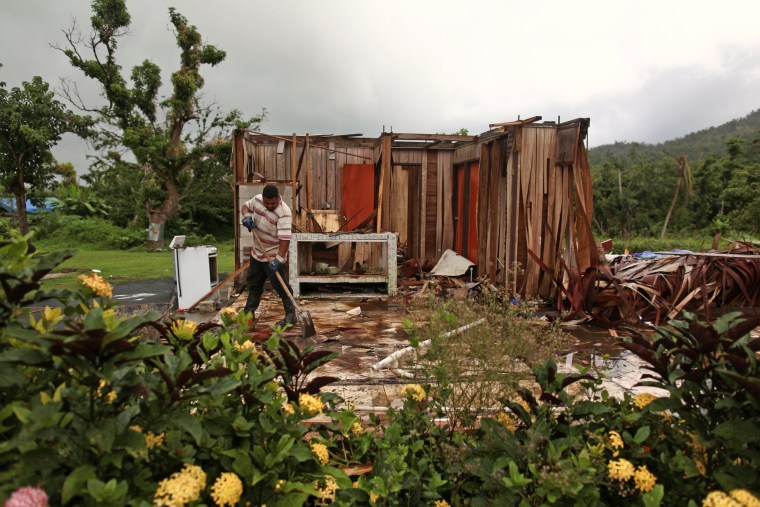 Image: Garcia removes debris in what is left of his home, in Maunabo