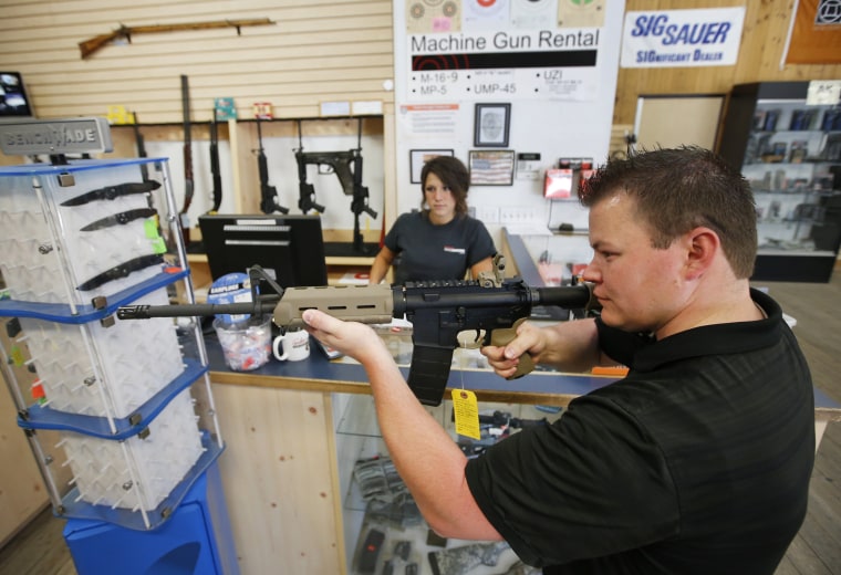 Image: An employee shows an AR-15 rifle to a customer