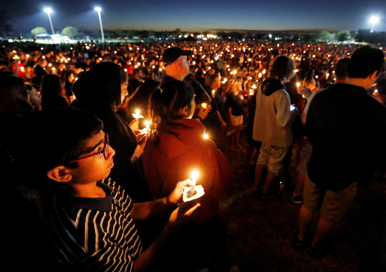 People attend a candlelight vigil.