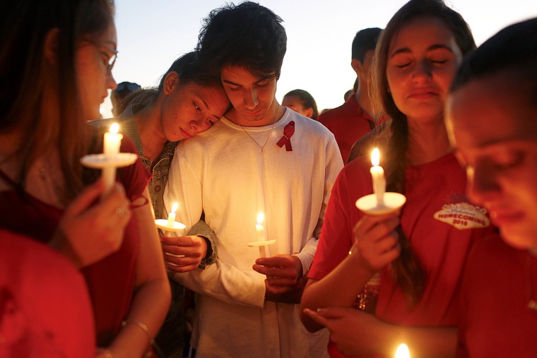 Students mourn at a candlelight vigil.