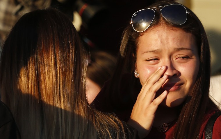 Students grieve after they placed flowers on a makeshift memorial.
