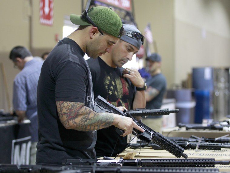 Image: Patrons peruse weapons at a gun show in Miami, Florida, Feb. 17, 2018.