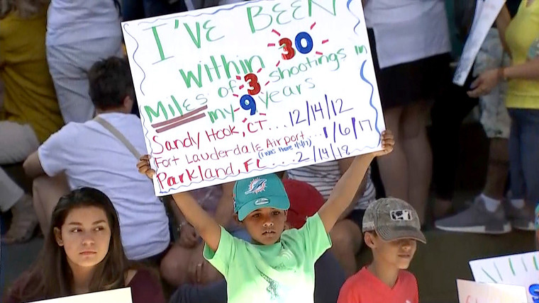 Image: A child holds a poster at a rally for gun control at the Broward County Federal Courthouse in Fort Lauderdale, Florida on Feb. 17, 2018.