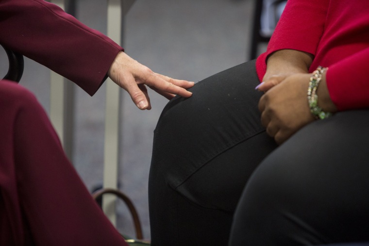 Image: Tara Bassett, development specialist, touches Kimberly Singleton knee for support during a presentation at Bridgehaven Mental Health Services.