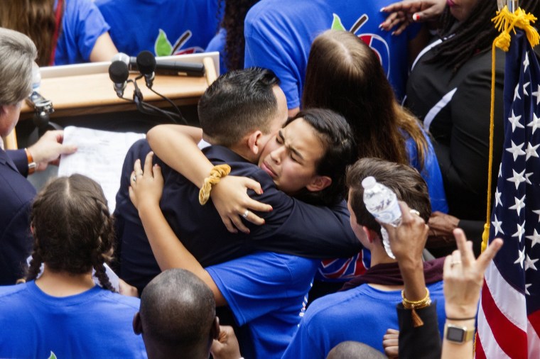 Image: Victoria Mejai, a sophomore from South Broward High School hugs Florida Rep. Carlos Guillermo Smith