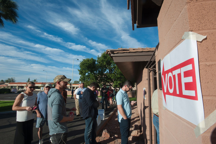 Image: Voters wait in line in front of a polling station  in Scottsdale, Arizona