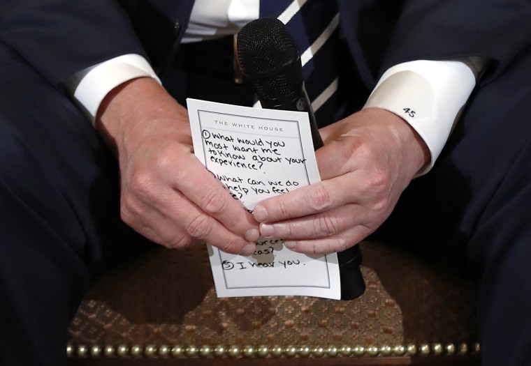 Image: Trump holds notes during a listening session with high school students