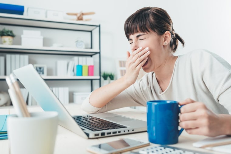 Image: Woman yawning at work