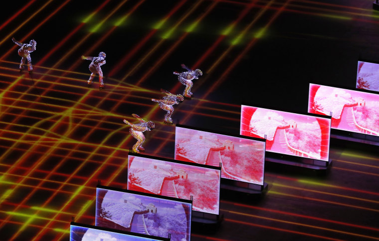Artists skate during a light show.