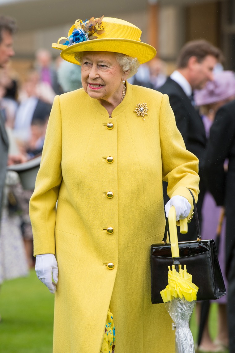 Queen Elizabeth II with umbrellas