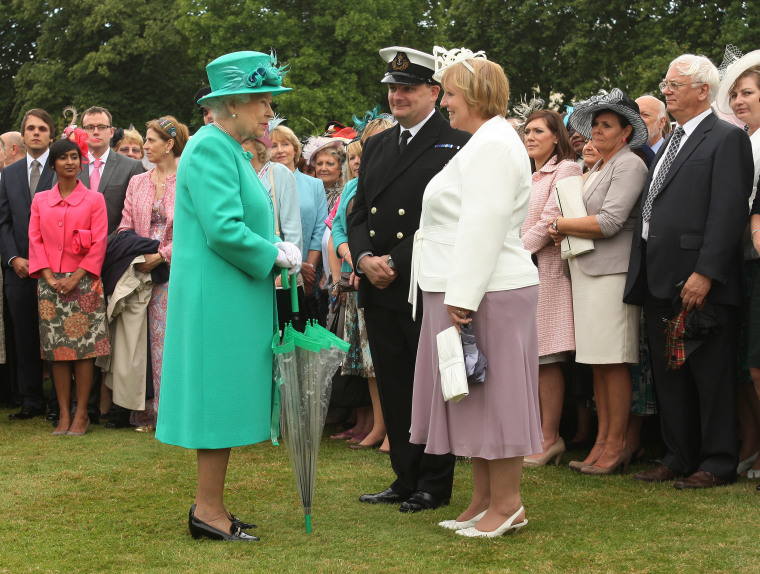 Queen Elizabeth II with umbrellas