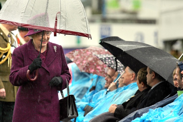 Queen Elizabeth II with umbrellas