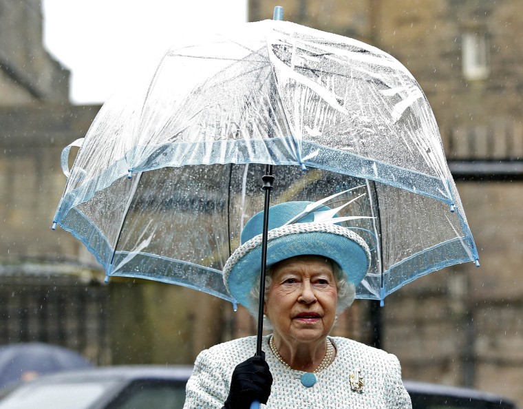 Queen Elizabeth II with umbrellas