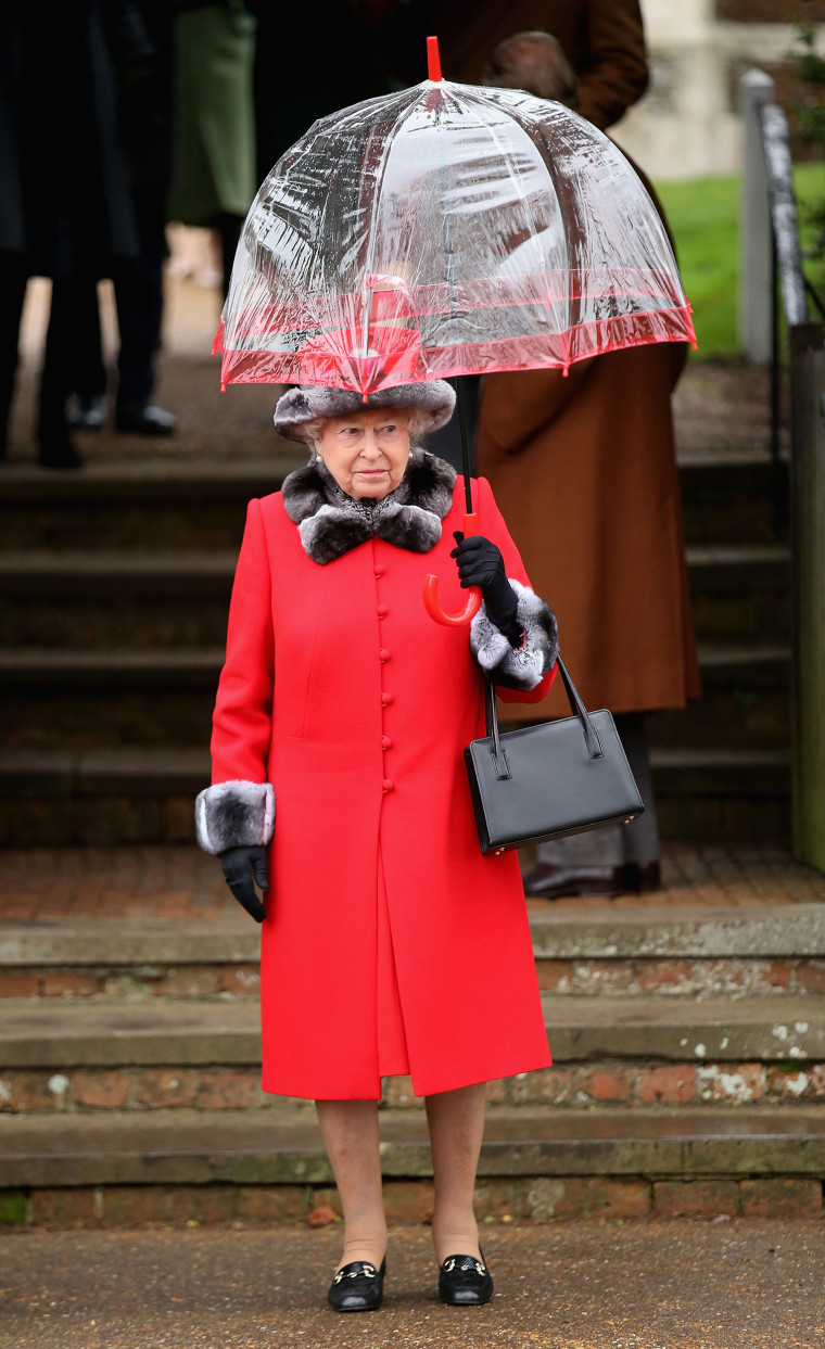 Queen Elizabeth II with umbrellas