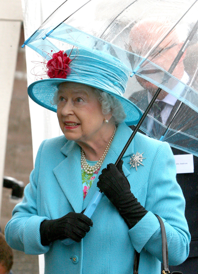 Queen Elizabeth II with umbrellas