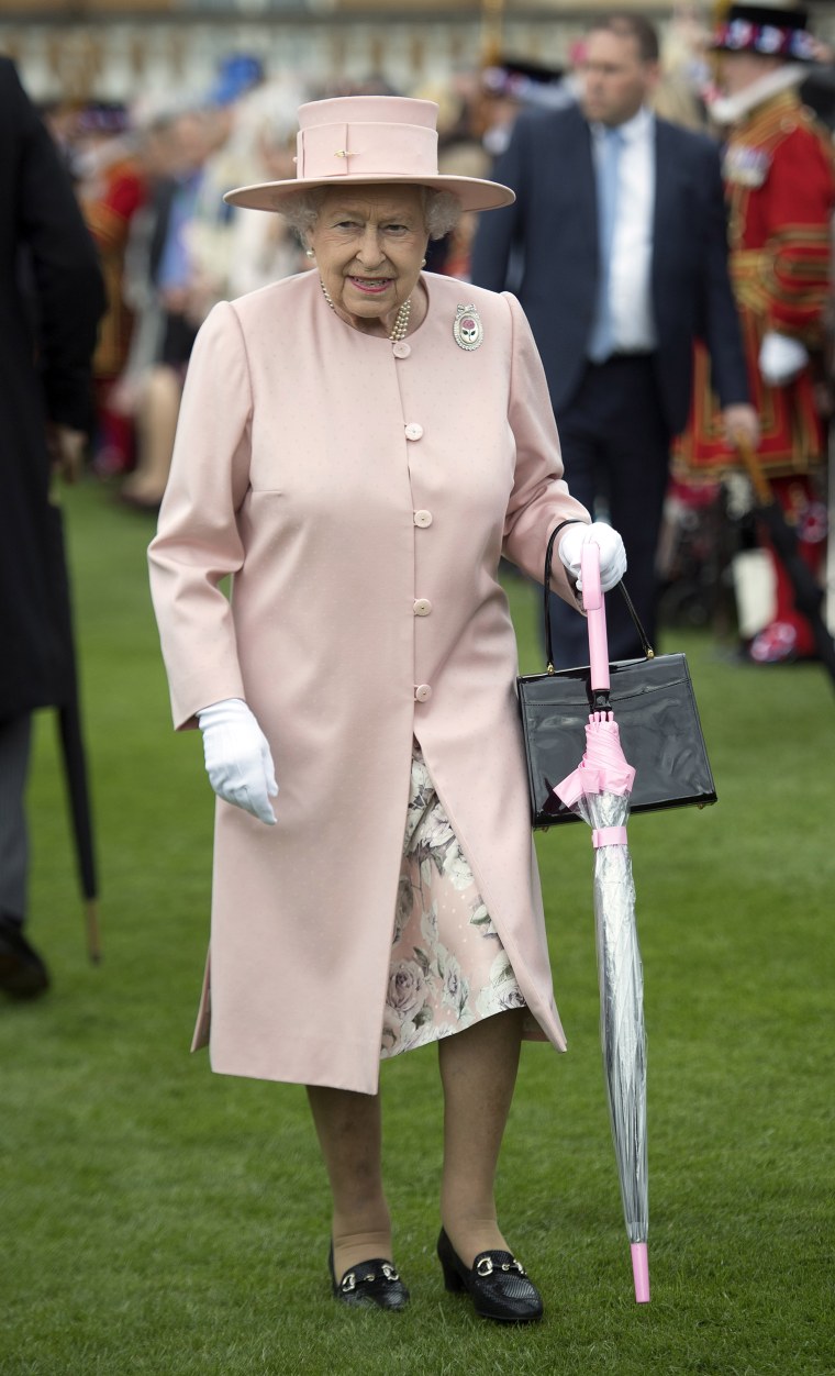 Queen Elizabeth II with umbrellas