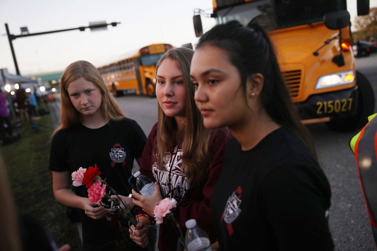 Image: Students wait at a crosswalk as they arrive to attend classes at Marjory Stoneman Douglas High School