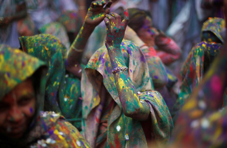 Image: Widows daubed in colours dance as they take part in Holi celebrations in the town of Vrindavan