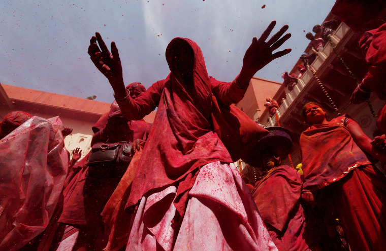 Image: Widows daubed in colours dance as they take part in Holi celebrations in the town of Vrindavan