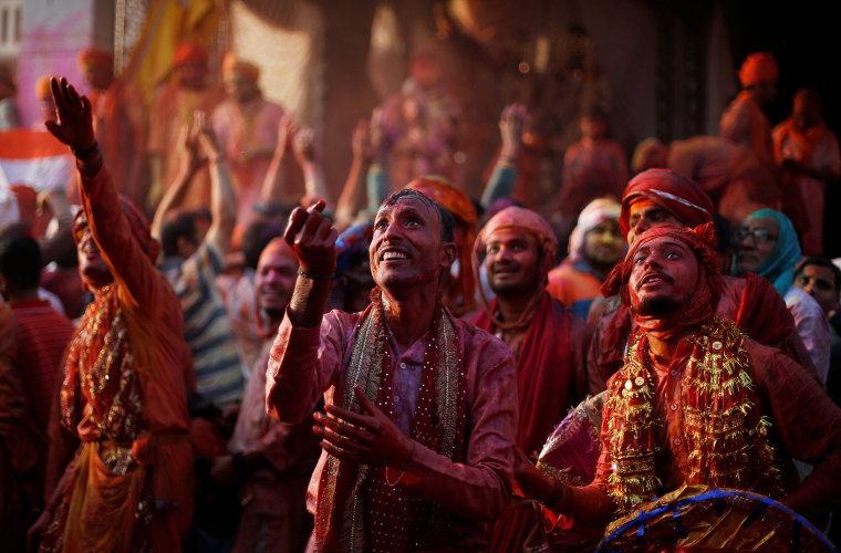 Image: Hindu devotees take part in the religious festival of Holi inside a temple in Nandgaon village