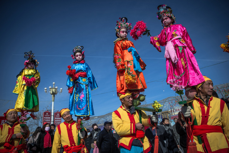 Image: Chinese folk artists perform during a parade celebrating the upcoming Lantern Festival