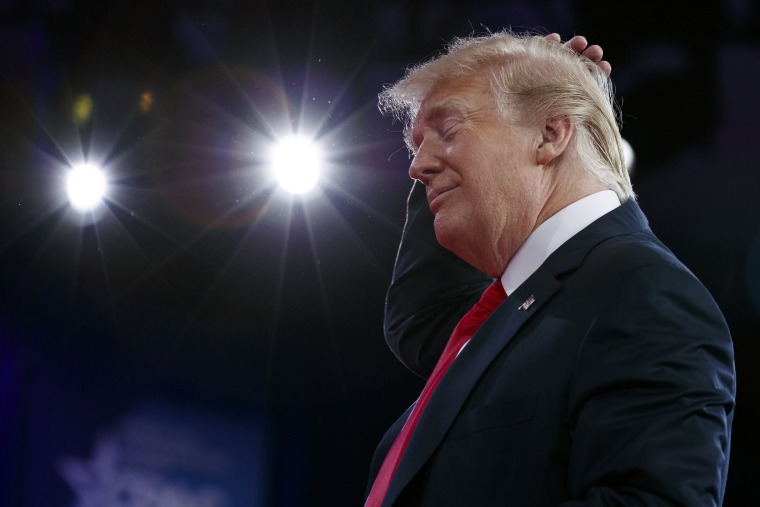 Image: Trump smooths his hair as he makes a joke