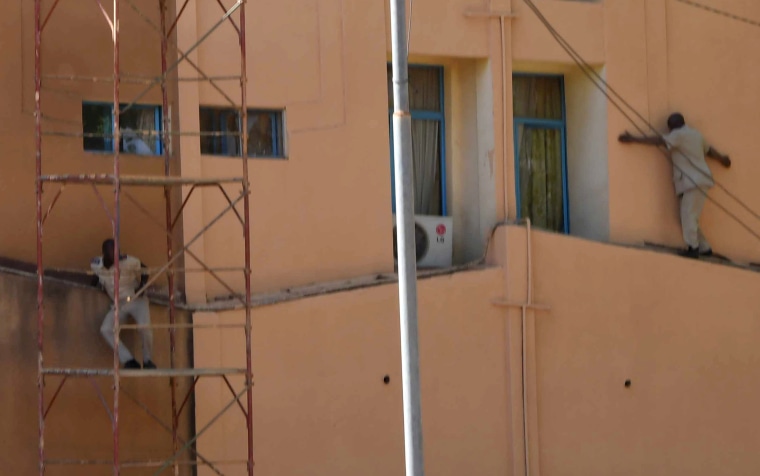 Image: Men escape from Burkina Faso's army headquarters during an attack in Ougadougou, Burkina Faso