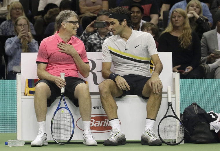 Bill Gates, left, smiles as he talks with partner Roger Federer, of Switzerland, as they play an exhibition tennis match against Jack Sock and Savannah Guthrie in San Jose, Calif., Monday, March 5, 2018.