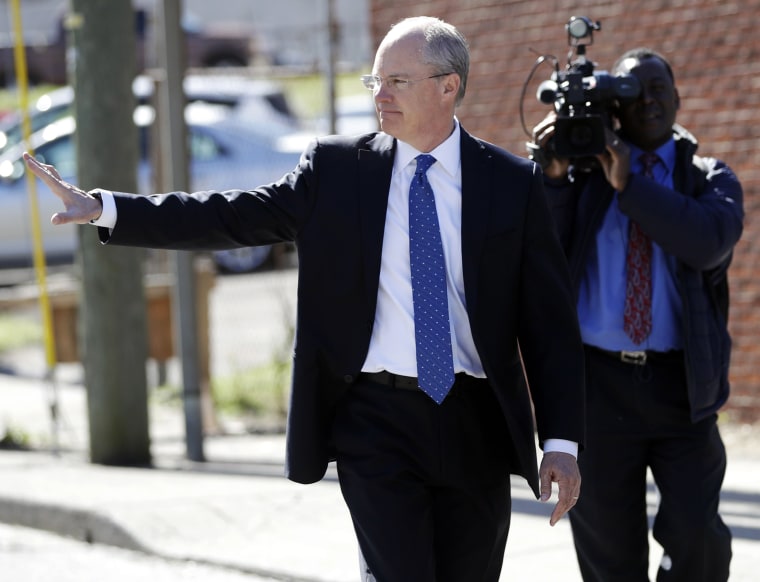 Image: Sgt. Robert Forrest waves as he walks to the Criminal Justice Annex