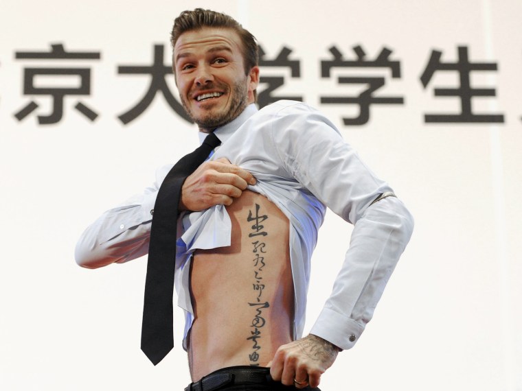 Image: David Beckham showing his tattoo after he was asked to by students at Peking University during his visit in Beijing