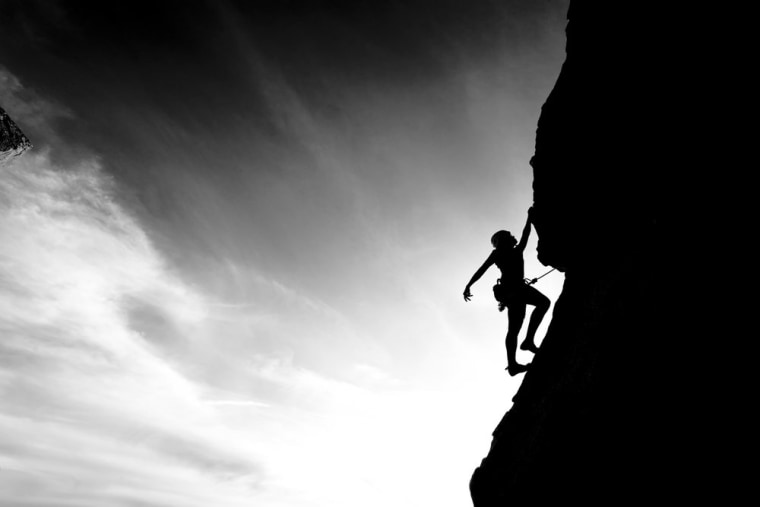 Image: A woman climbs a mountain