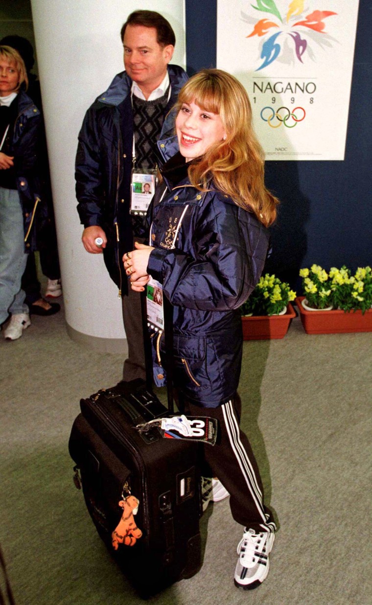 Image: U.S. figure skater Tara Lapinski, 15, wheels her luggage as she and her coach Richard Callaghan walk through Nagano's White Ring arena