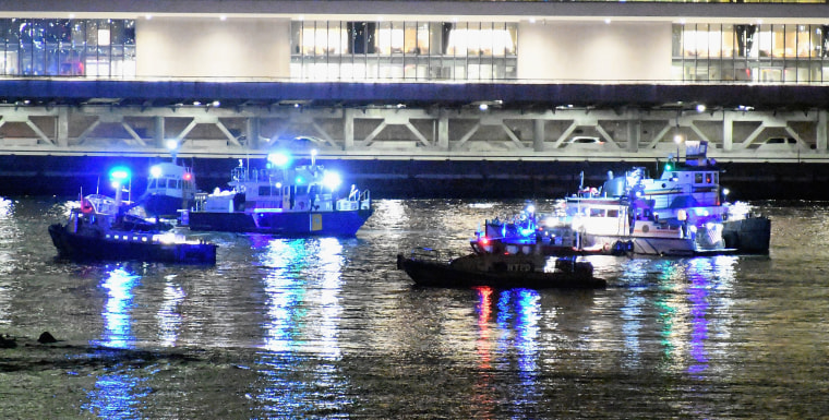 Image: Emergency responders work at the scene of a helicopter crash in the East River