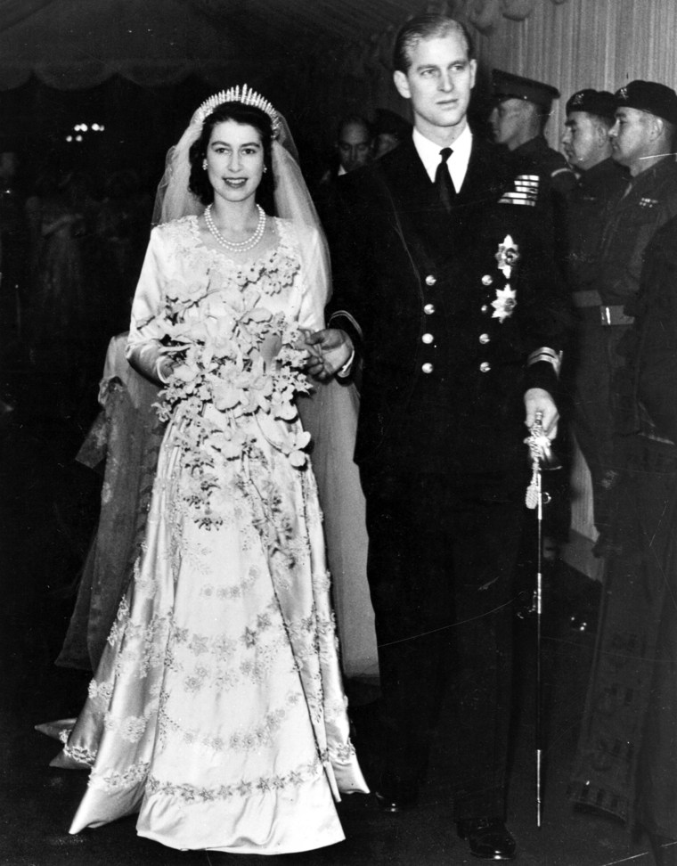 Princess Elizabeth wed Philip Mountbatten in 1947 in Westminster Abbey. Designed by Norman Hartnell, the dress was made of ivory satin and embroidered with flowers and thousands of pearls imported from the U.S. The queen famously saved her ration cards in order to buy the material used in the dress. The diamond tiara originally belonged to her grandmother, Queen Mary, and was then handed down to Elizabeth's mother who lent it to her daughter for the wedding.