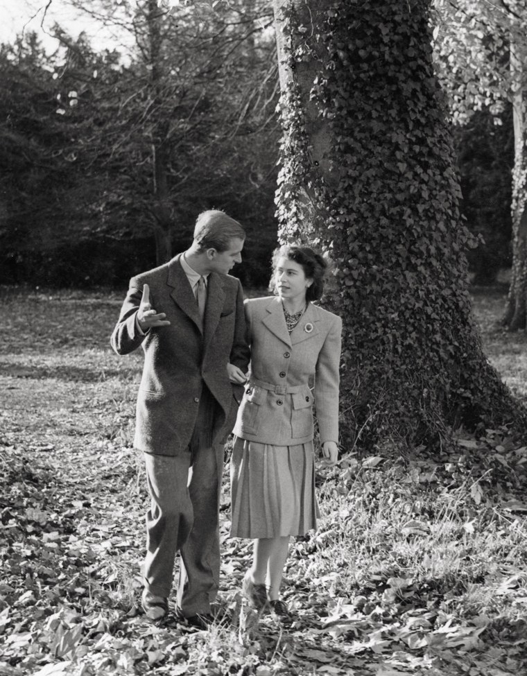 Ever formal even while on their honeymoon, Princess Elizabeth and the newly named Duke of Edinburgh take a stroll on the day after their wedding through the grounds of Broadlands, the Duke's uncle's home.