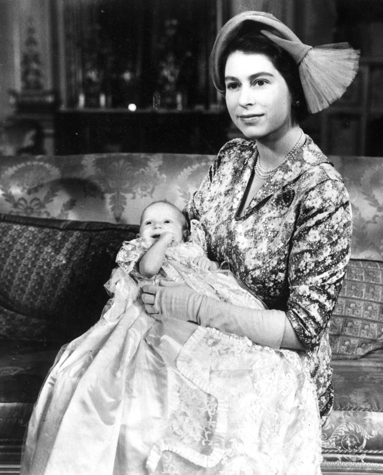 Princess Elizabeth, in a jaunty hat, shows off her new baby daughter, Princess Anne, on the day of her christening in October 1950. The lace christening gown is a royal family heirloom, and was originally worn by Queen Victoria's eldest daughter in 1841, as well as by Elizabeth herself.