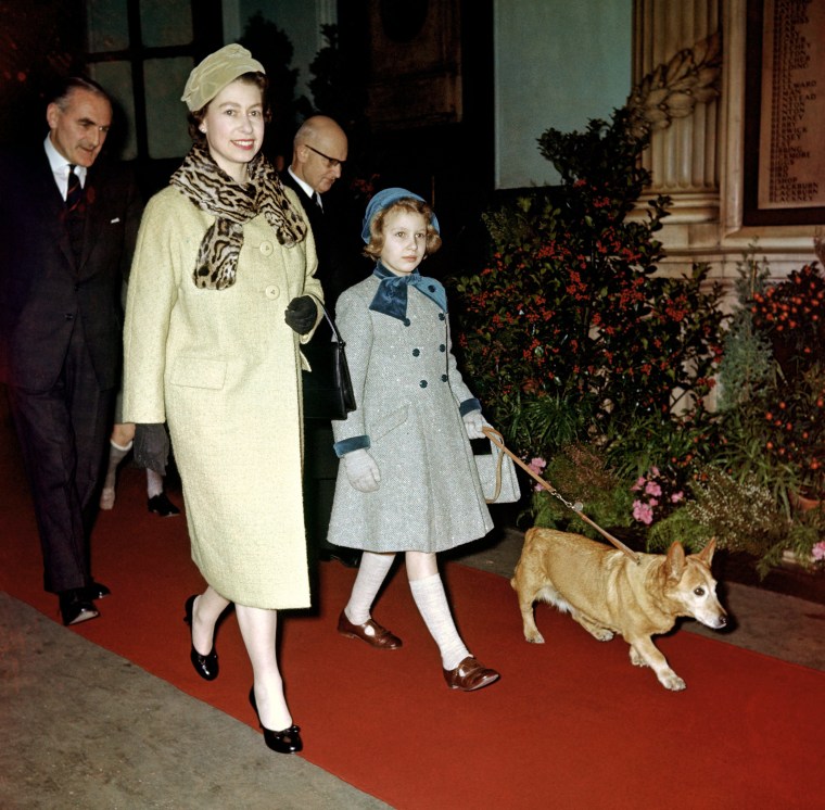 Queen Elizabeth with Princess Anne and one of her Corgis at Liverpool Street Station, London.