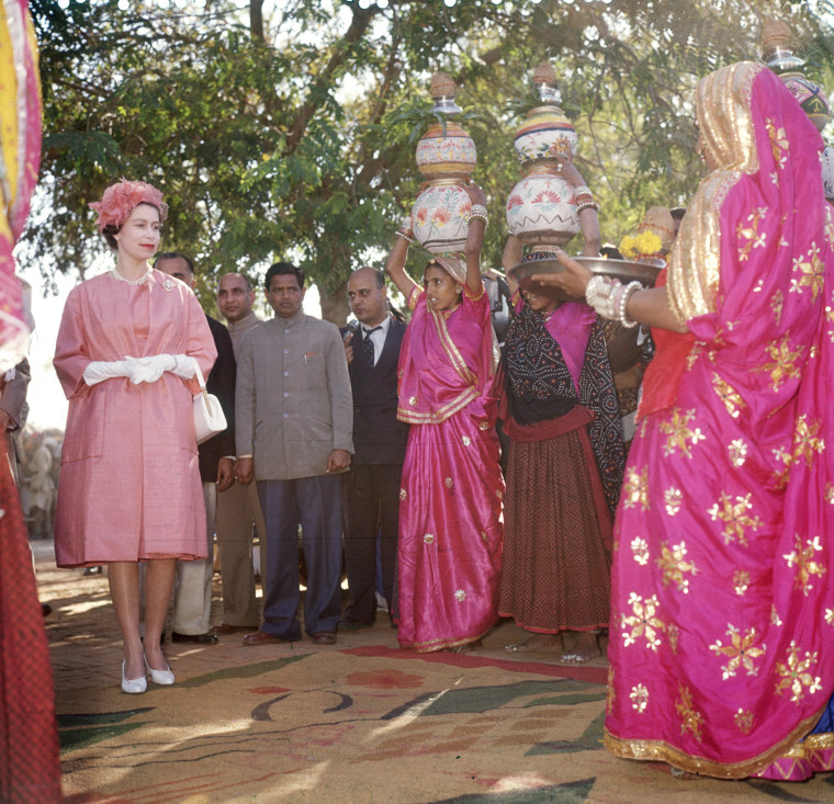Ever the fan of bright colors, Queen Elizabeth stands out in hot pink on a visit to a model village in Jaipur, also known as the \"pink city,\" during a royal tour of India and Pakistan in January 1961.
