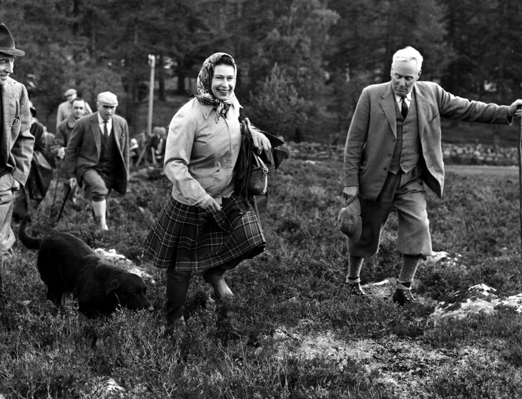 Queen Elizabeth walks with her dog Wren at the Open Stake Retriever Trials on her Balmoral estate in October 1967. For the relaxed atmosphere, the queen tied a scarf around her head, one of her signature looks throughout her reign.